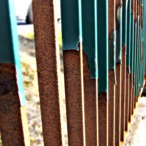 worn rusted steel fence