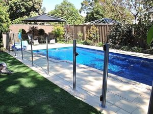 Semi-frameless glass fence surrounding a pool