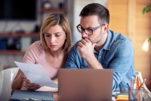 Man and woman at a laptop discussing how to build a picket fence